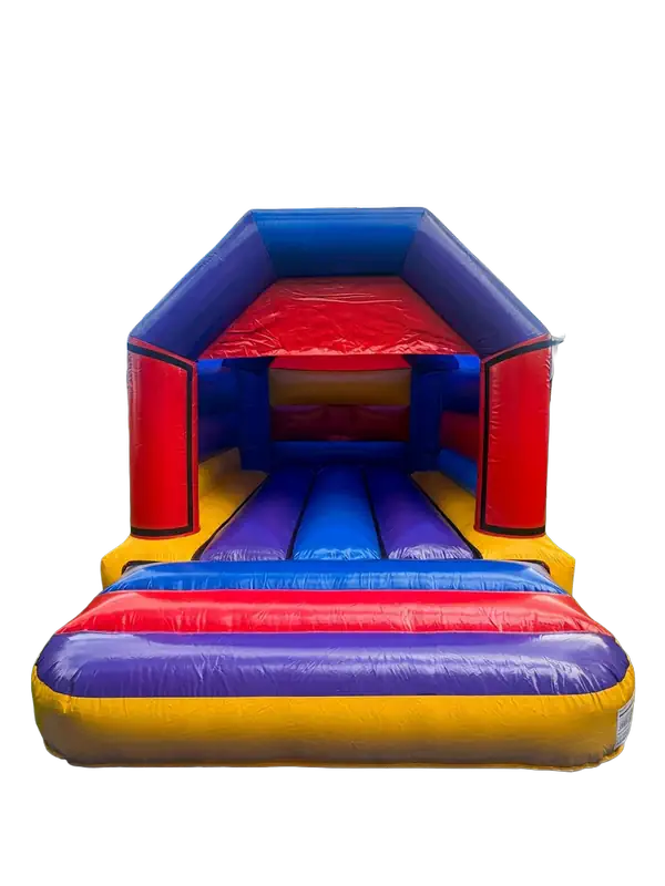 A vibrant pink and purple party bouncy castle set up on a green lawn.